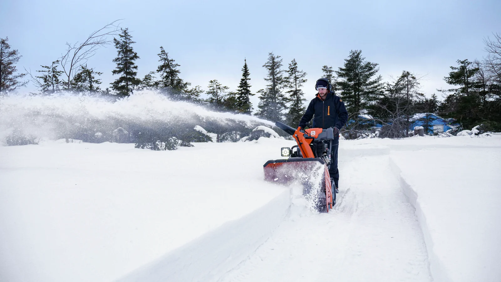 Man använder en Husqvarna snöslunga i djup snö