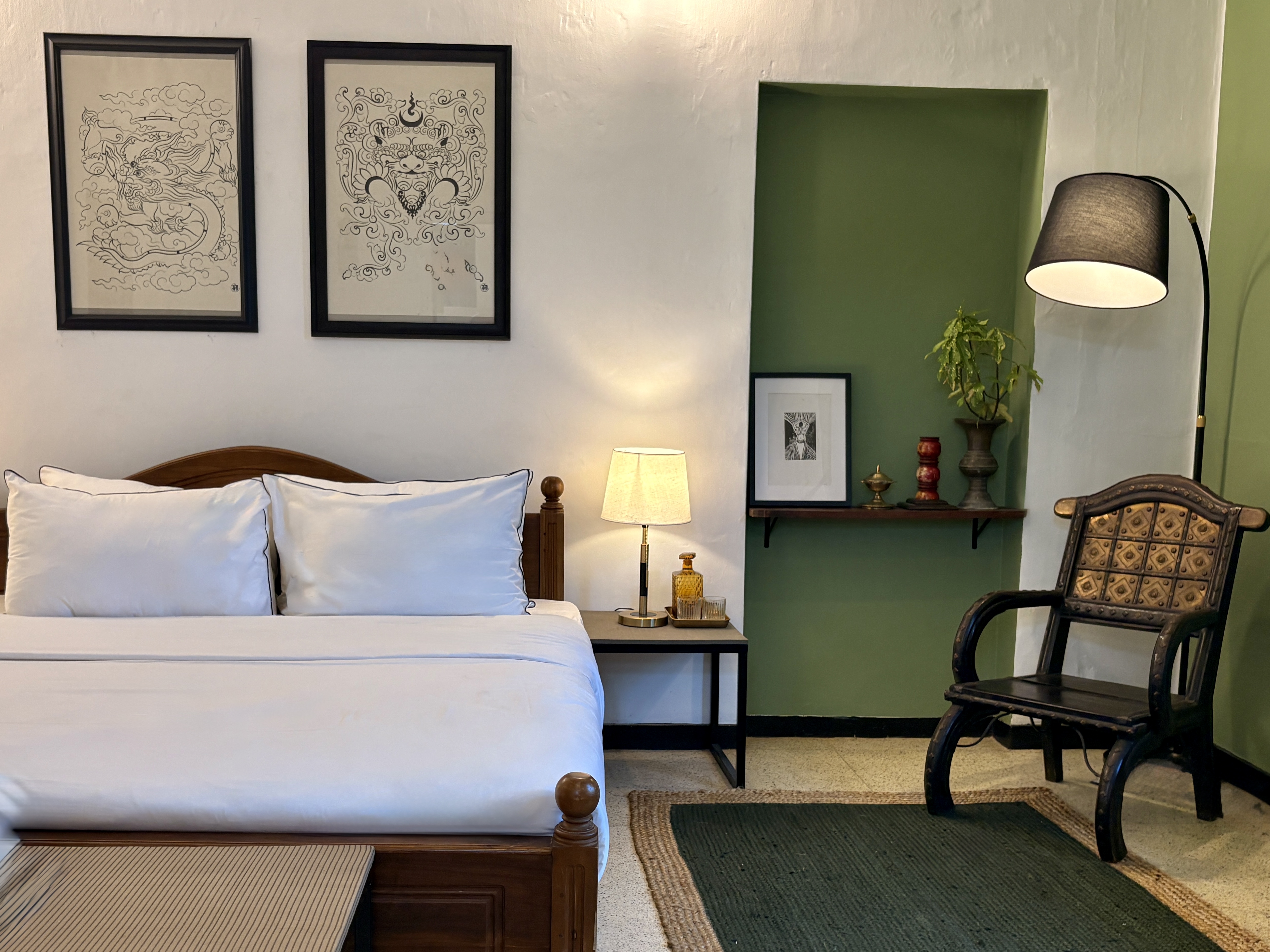 The bed, sage-green niche and reading chair in the supplied Black Cat Stay photograph