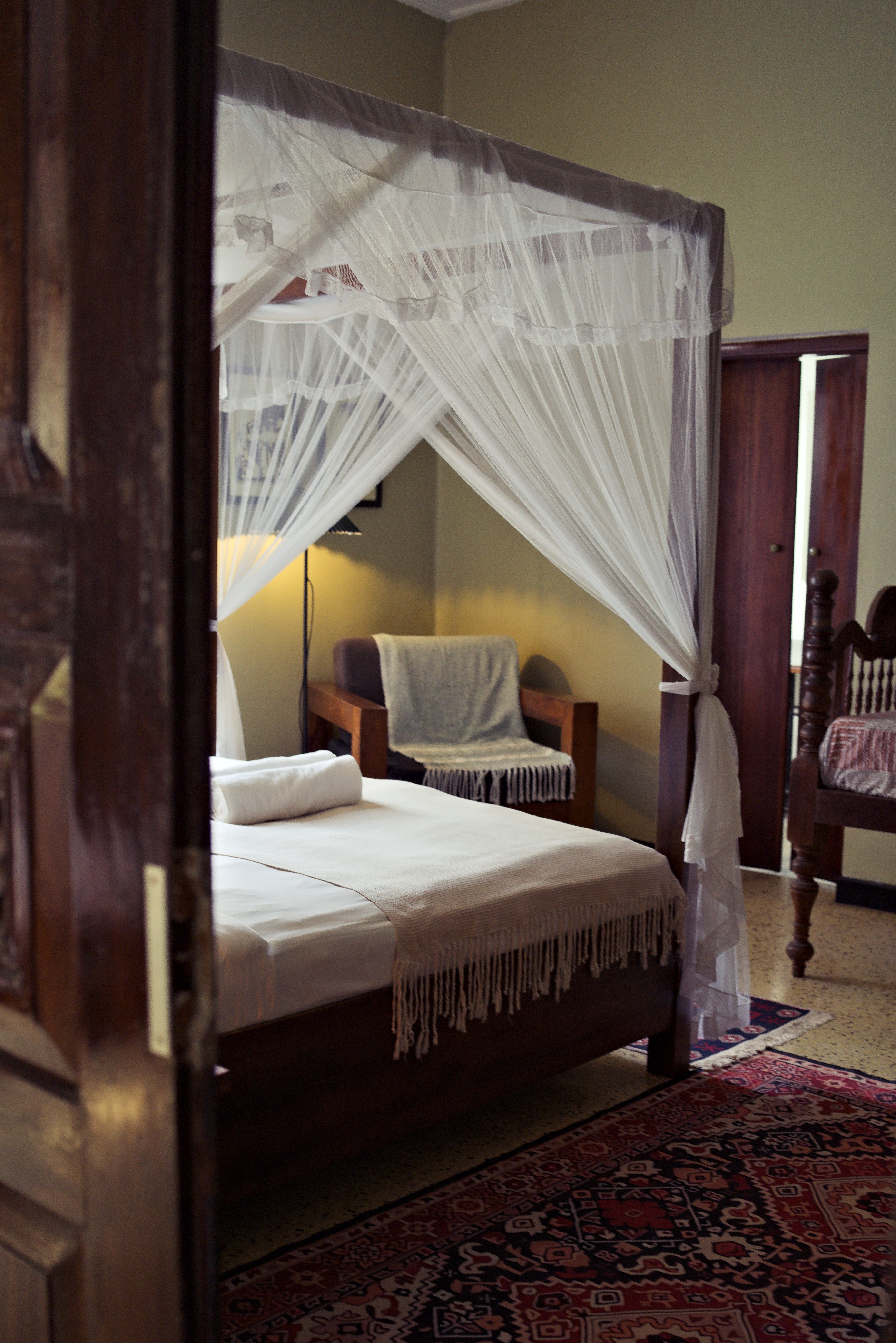A canopy bed and wooden furniture in a room at Black Cat Stay