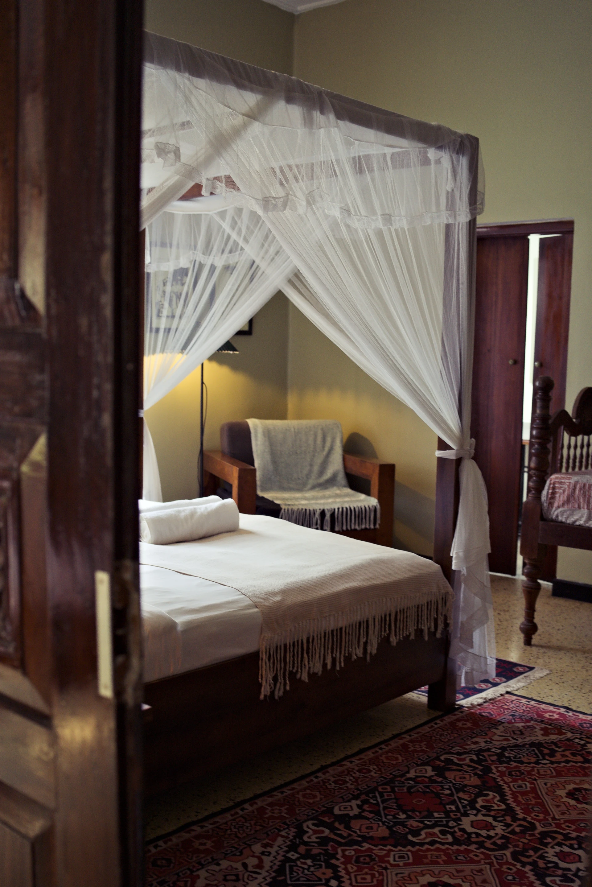 A canopy bed and wooden furniture in a room at Black Cat Stay